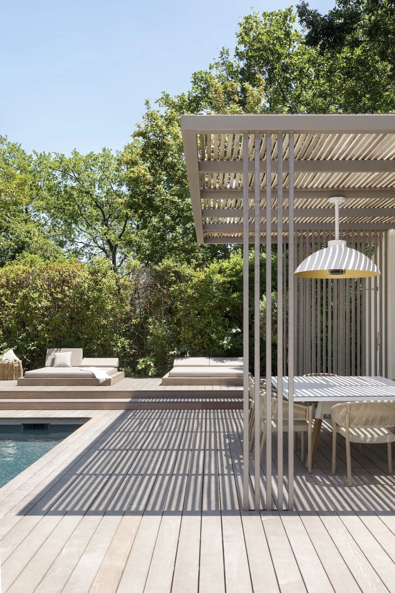 Espace extérieur avec mobilier en bois teak, pergola et piscine à Aix-en-Provence.