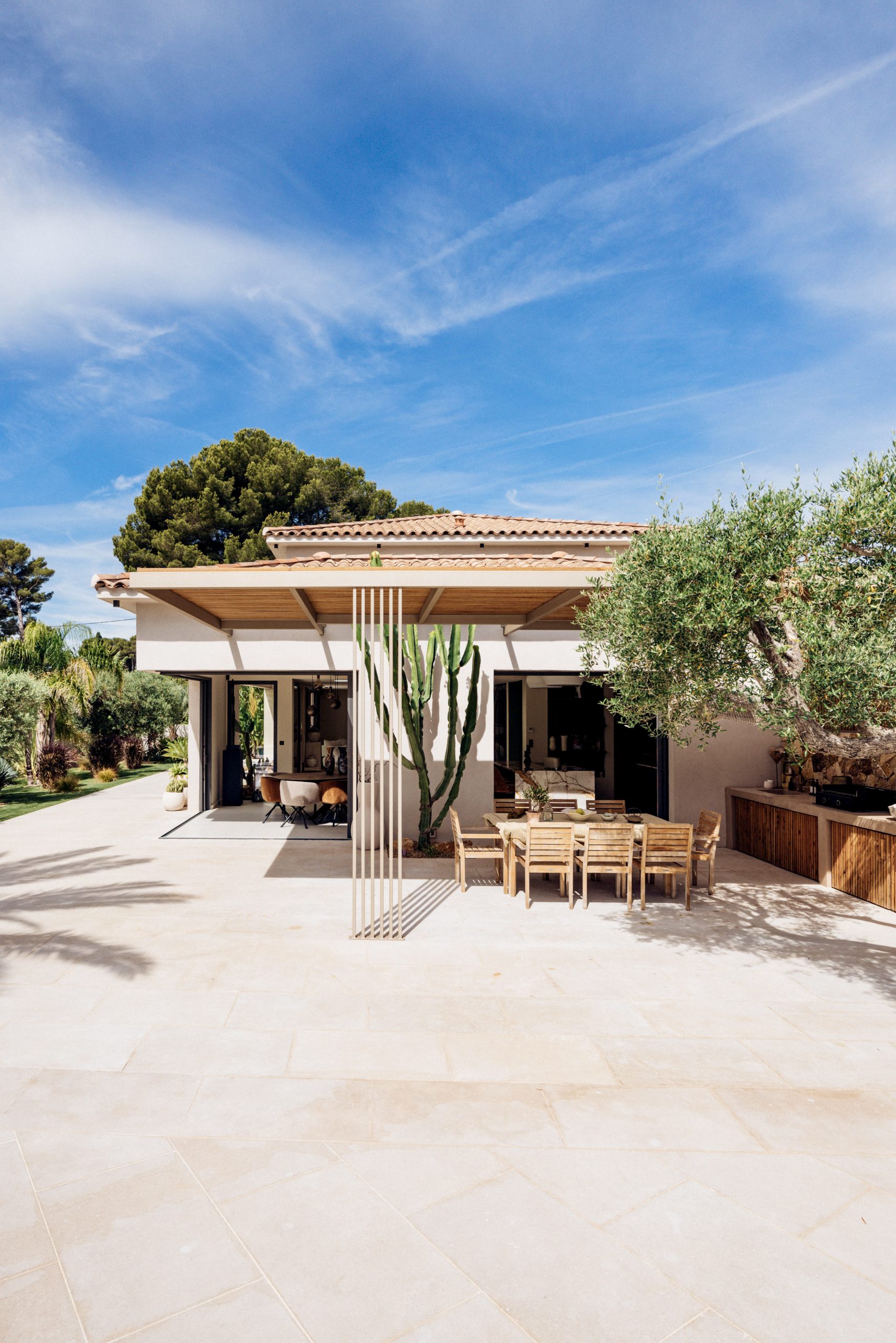 Pergola en bois exotique sur mesure devant villa provençale à Sanary-sur-Mer, table à manger extérieure en teck